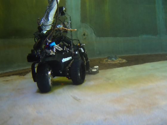The VAC Boss crawler on a reservoir floor with its camera mast and suction hose, seen under the water.